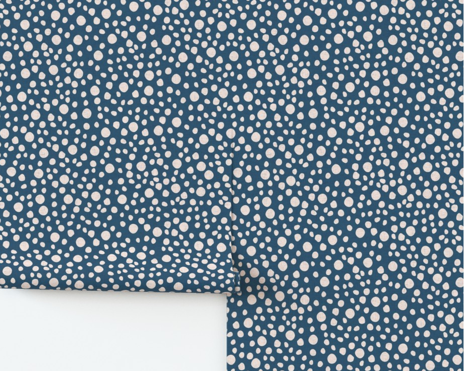 Roll of blue wallpaper with white dot pattern on a white background