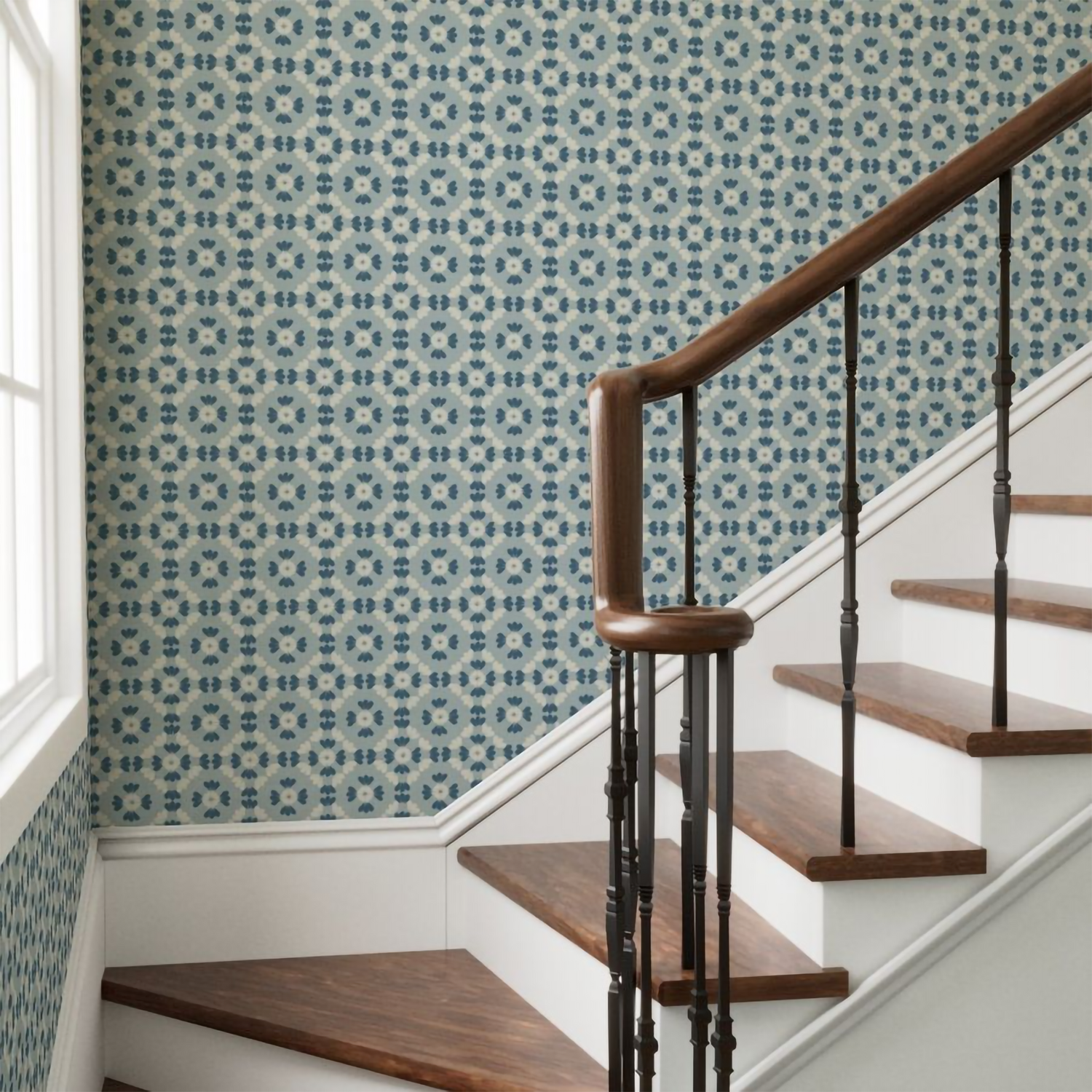 Staircase with wooden steps and handrail against a blue floral geometric tile patterned wallpaper wall.