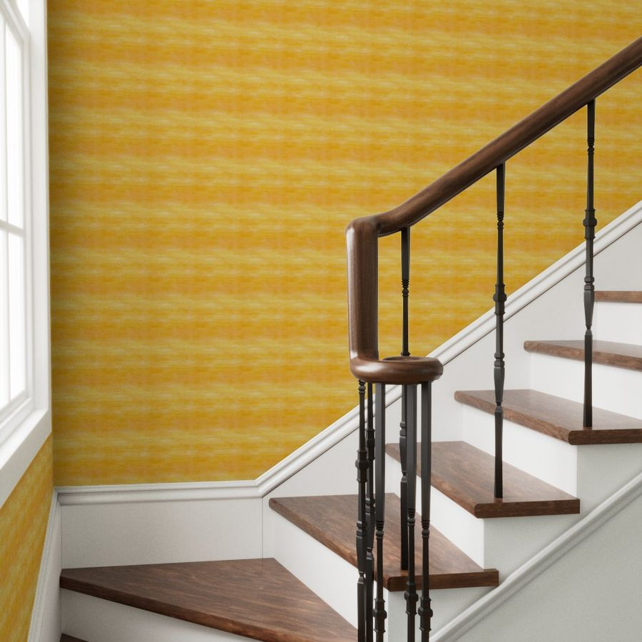 Staircase with wooden steps and handrail against a yellow wallpapered grasscloth wall.